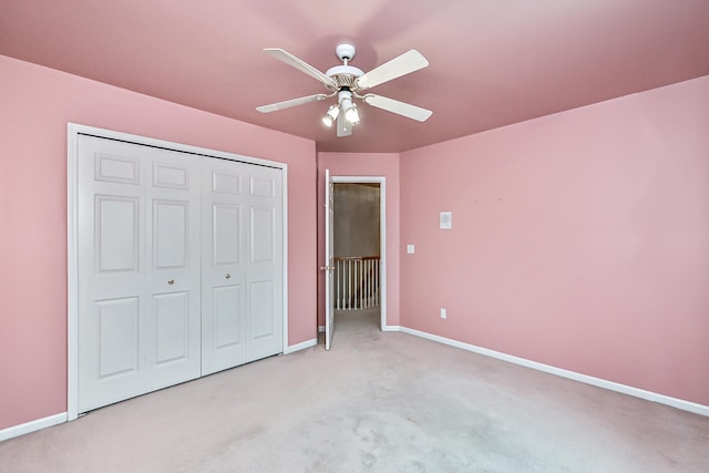 unfurnished bedroom with light colored carpet, a closet, and ceiling fan