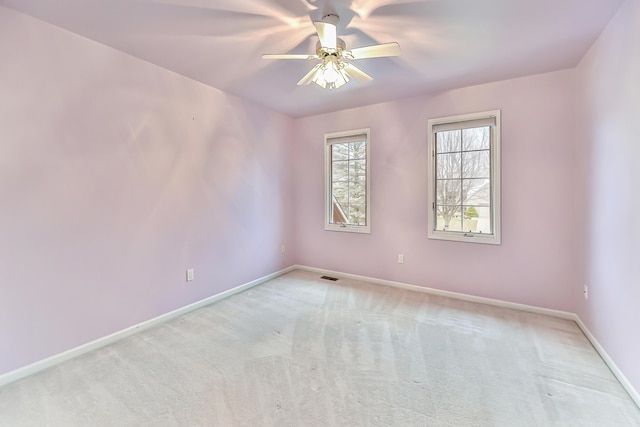 spare room featuring light carpet and ceiling fan