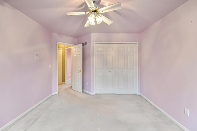 unfurnished bedroom featuring light carpet, a closet, and ceiling fan