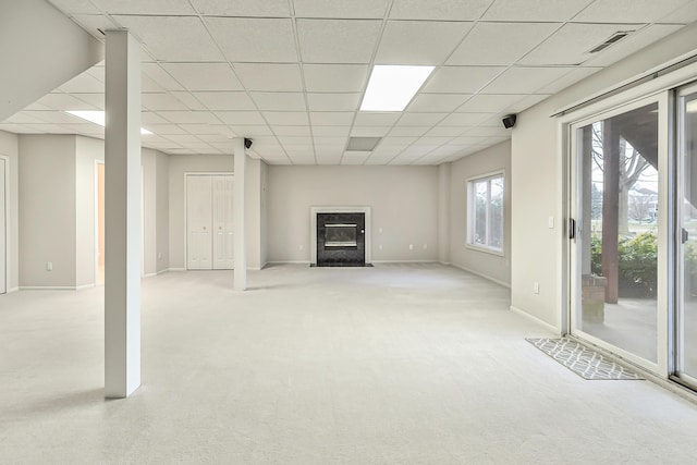 basement with light carpet and a paneled ceiling