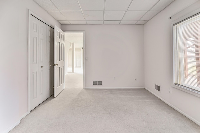 carpeted spare room with a paneled ceiling and a wealth of natural light