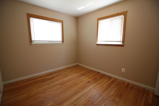 unfurnished room featuring hardwood / wood-style flooring and a healthy amount of sunlight