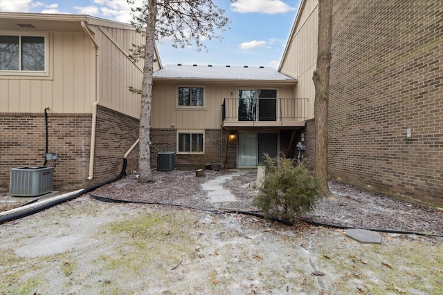 rear view of house with central AC and a balcony