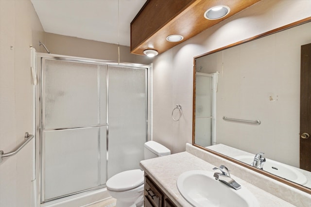 bathroom featuring vanity, an enclosed shower, and toilet