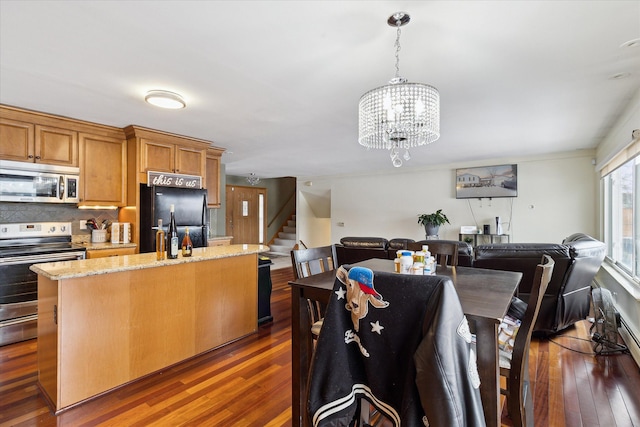 dining area featuring stairway, dark wood finished floors, and a notable chandelier