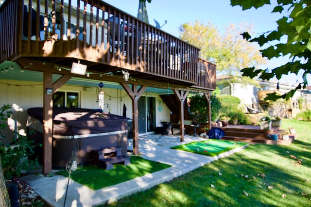 back of property with a deck, a lawn, a patio area, and a hot tub