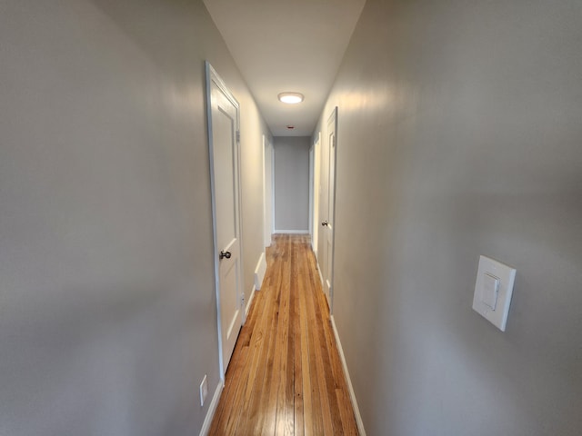 corridor with light hardwood / wood-style floors