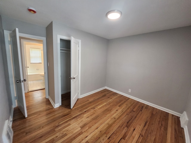 unfurnished bedroom featuring hardwood / wood-style flooring and a closet