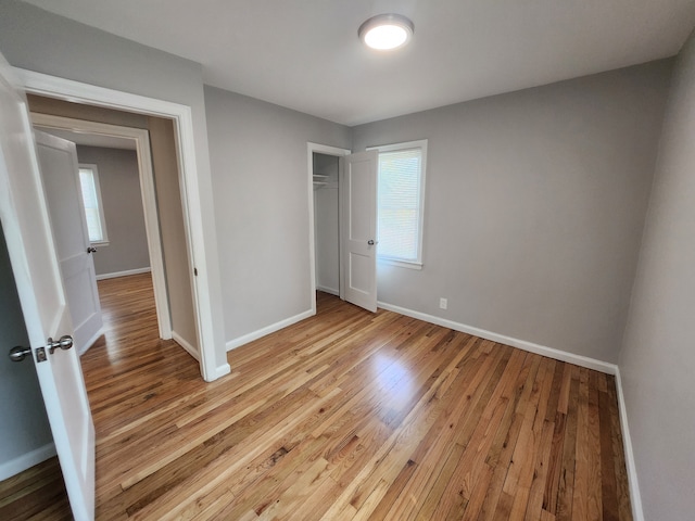 unfurnished bedroom with light hardwood / wood-style floors and a closet