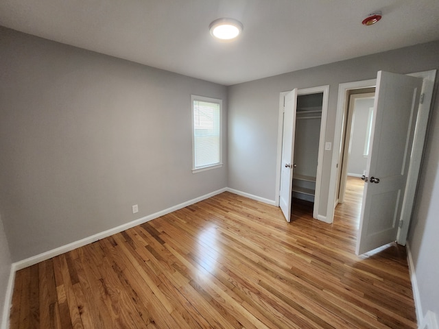 unfurnished bedroom with a closet and light wood-type flooring