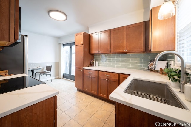 kitchen with hanging light fixtures, plenty of natural light, sink, and decorative backsplash