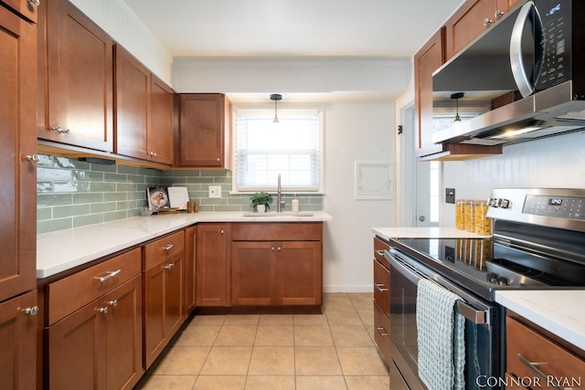 kitchen with appliances with stainless steel finishes, decorative light fixtures, tasteful backsplash, sink, and light tile patterned floors