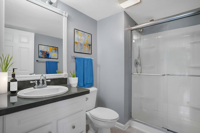 bathroom featuring toilet, vanity, and an enclosed shower