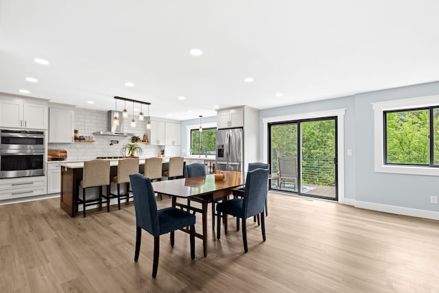 dining room featuring a healthy amount of sunlight, light hardwood / wood-style floors, and sink