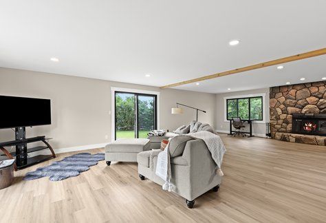 living room with beam ceiling, a fireplace, and light wood-type flooring