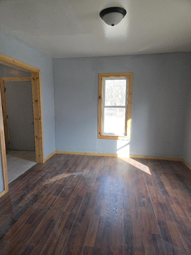 spare room with wood finished floors and baseboards