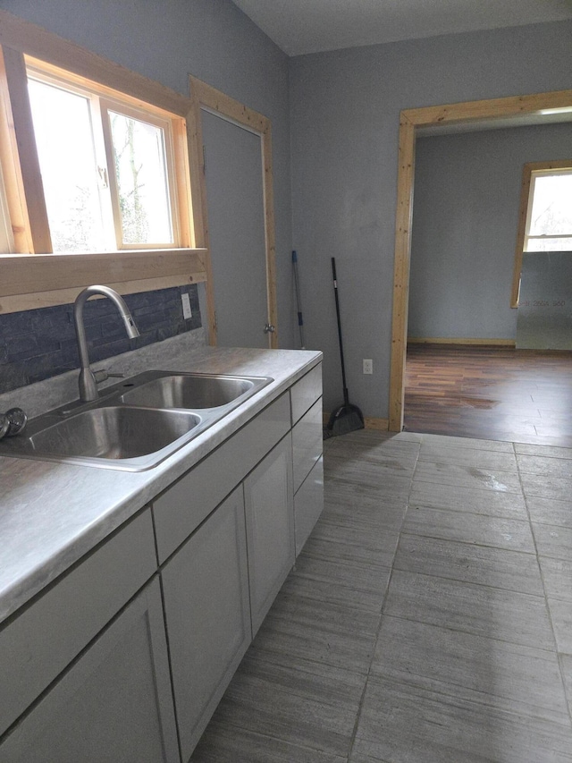 kitchen featuring a sink, white cabinetry, and light countertops