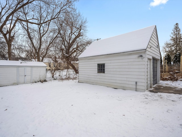 yard covered in snow with a garage and an outdoor structure