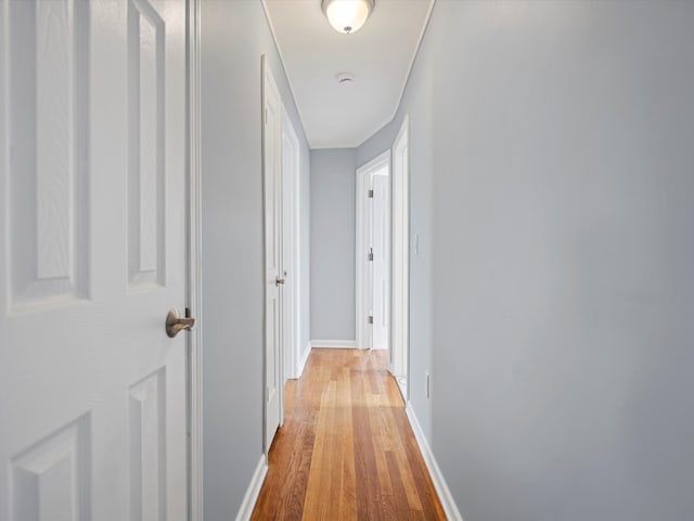 corridor featuring baseboards and wood finished floors