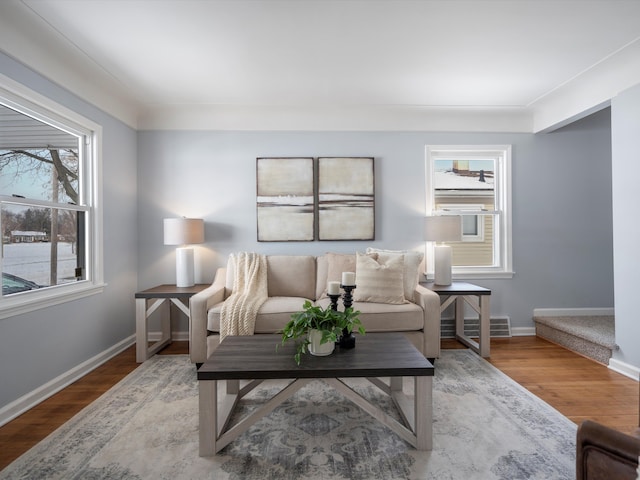 living area featuring visible vents, baseboards, and wood finished floors