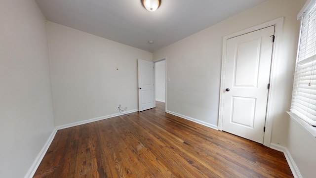 unfurnished bedroom with dark hardwood / wood-style flooring