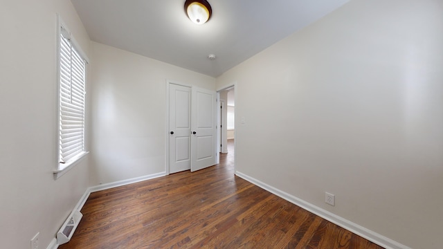 unfurnished room with dark hardwood / wood-style flooring