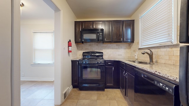 kitchen with black appliances, sink, backsplash, dark brown cabinetry, and light stone counters