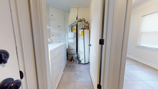 bathroom with water heater, vanity, separate washer and dryer, and tile patterned floors