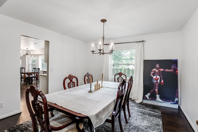 dining room with a healthy amount of sunlight, dark hardwood / wood-style flooring, and a notable chandelier