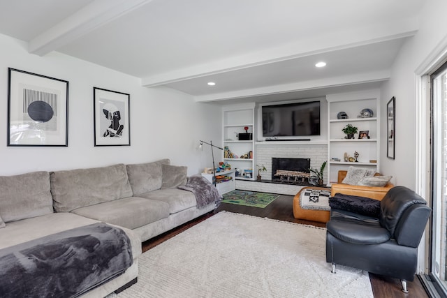 living room featuring a brick fireplace, beam ceiling, and hardwood / wood-style flooring