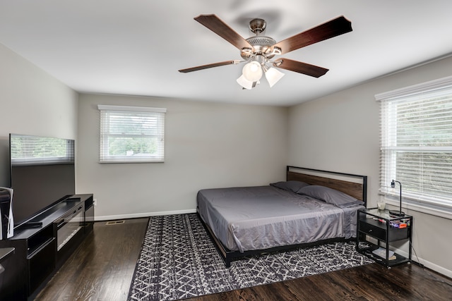 bedroom with dark wood-type flooring, ceiling fan, and multiple windows