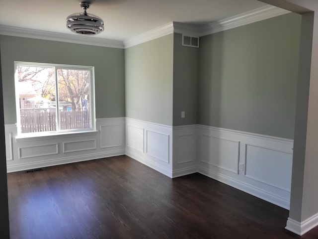 spare room with ornamental molding and dark hardwood / wood-style flooring