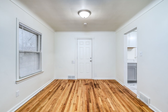 empty room with light hardwood / wood-style flooring