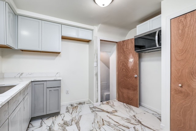 kitchen featuring gray cabinets and light stone countertops