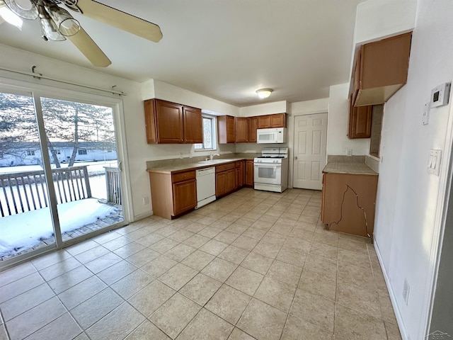 kitchen featuring ceiling fan, white appliances, light tile patterned flooring, and sink