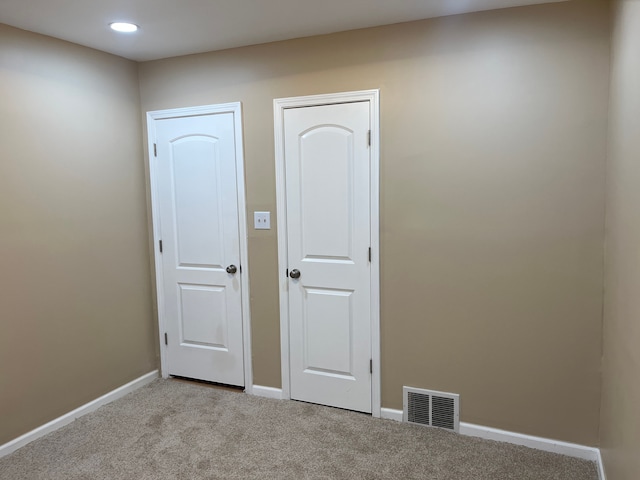 spare room featuring light carpet