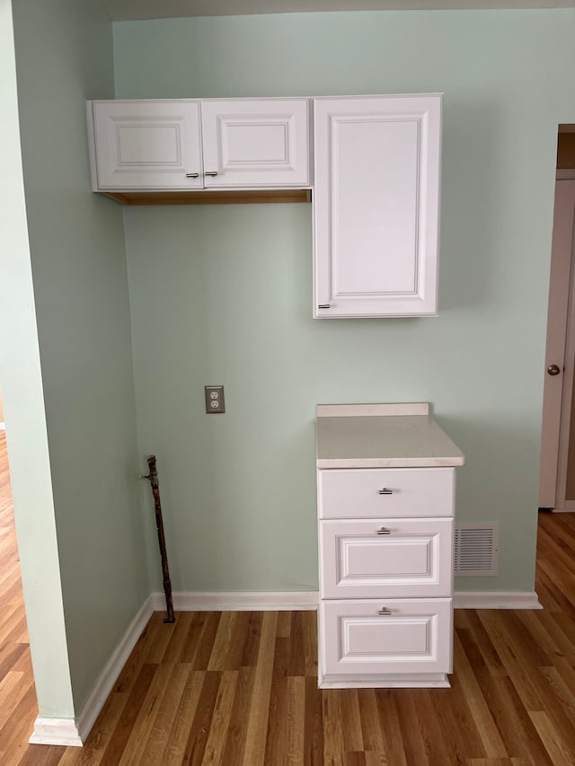 clothes washing area with dark wood-type flooring