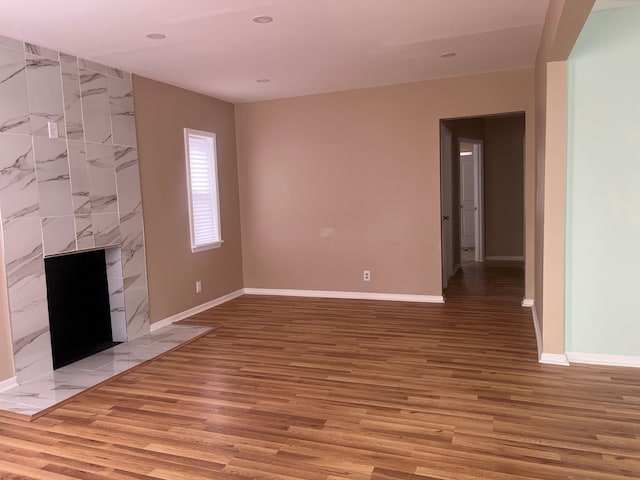 unfurnished living room with light wood-type flooring and a high end fireplace