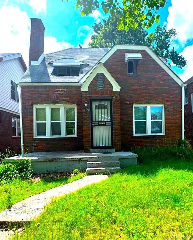 bungalow-style home featuring brick siding and a chimney