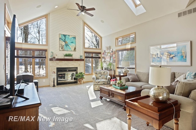 living room featuring plenty of natural light, carpet, a fireplace, and a skylight