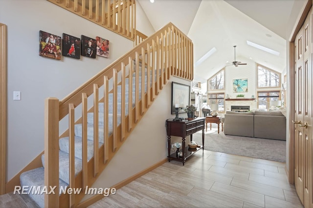 stairs with high vaulted ceiling and ceiling fan