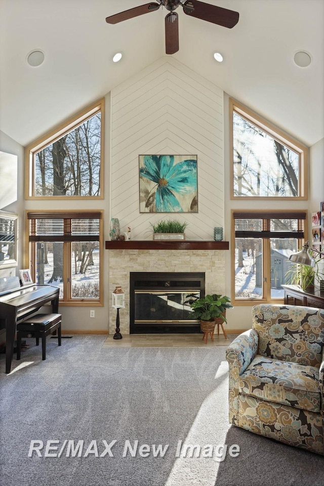 carpeted living room featuring high vaulted ceiling, a healthy amount of sunlight, and a fireplace