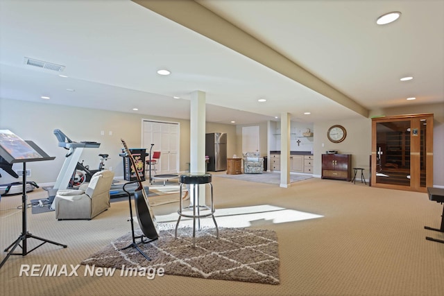 workout room featuring light carpet