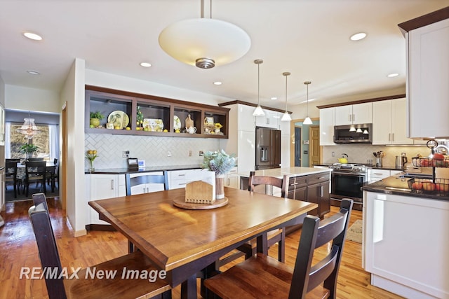 dining space with sink and light hardwood / wood-style flooring