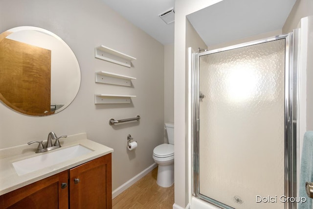 bathroom featuring hardwood / wood-style floors, vanity, toilet, and a shower with shower door