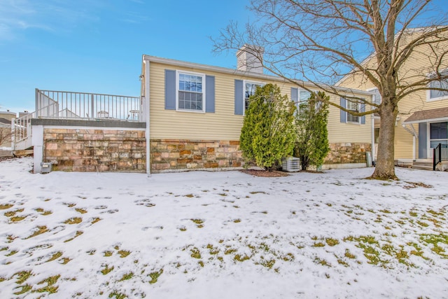 snow covered property with cooling unit