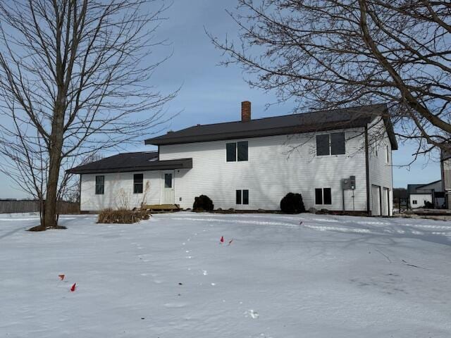 view of snow covered rear of property