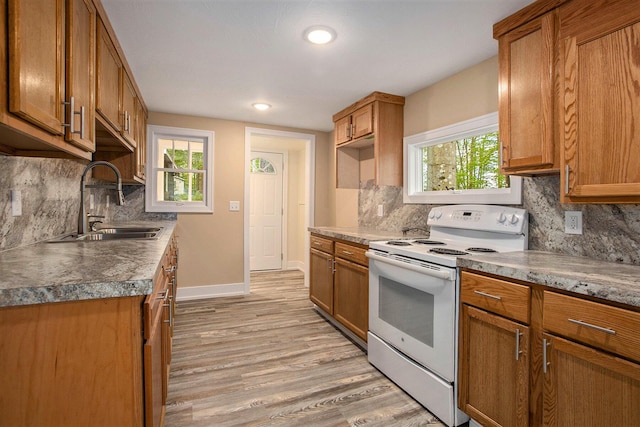 kitchen with sink, light wood-type flooring, a healthy amount of sunlight, and white electric range oven