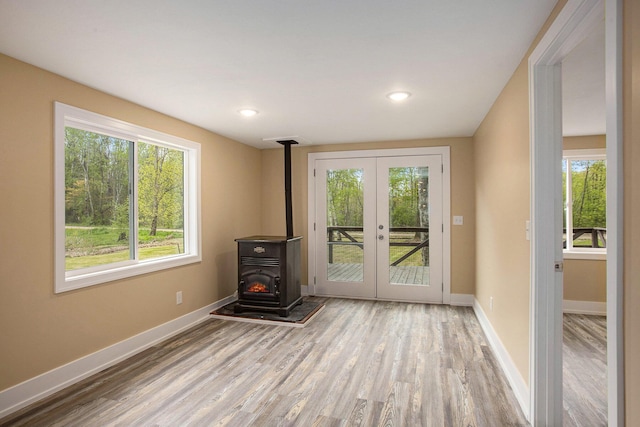 doorway featuring light hardwood / wood-style flooring, french doors, and a wood stove