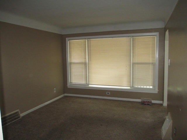 spare room with dark carpet